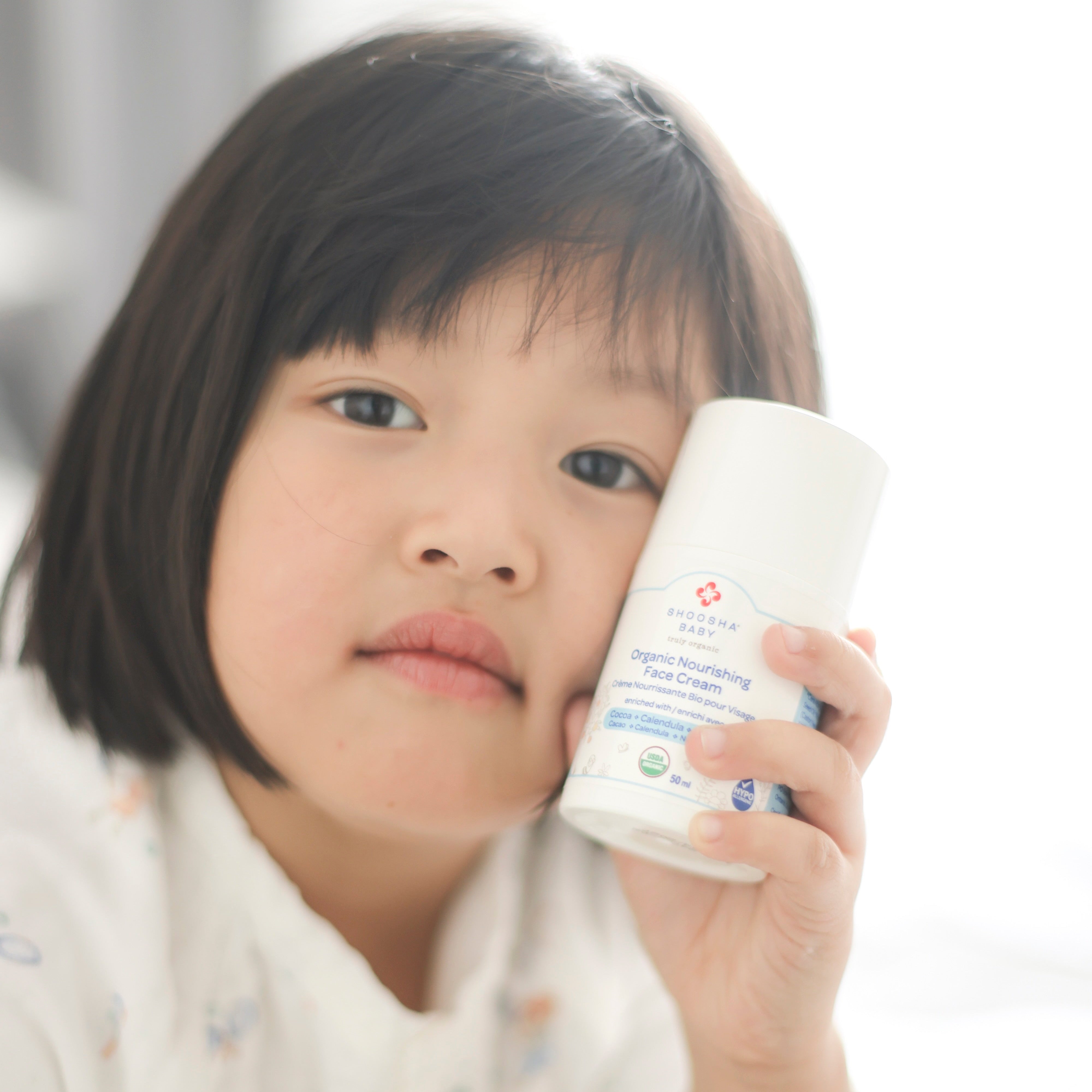 Girl holding USDA certified organic face cream