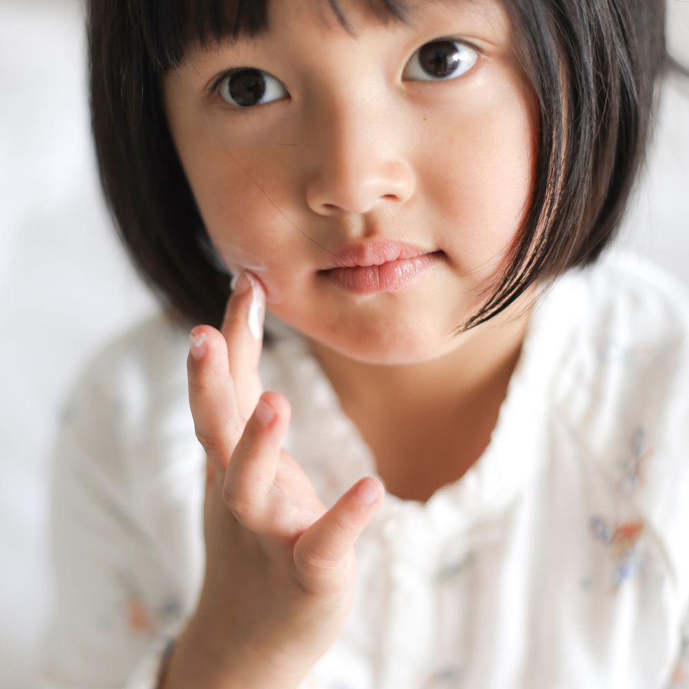 Girl applying USDA certified organic face cream