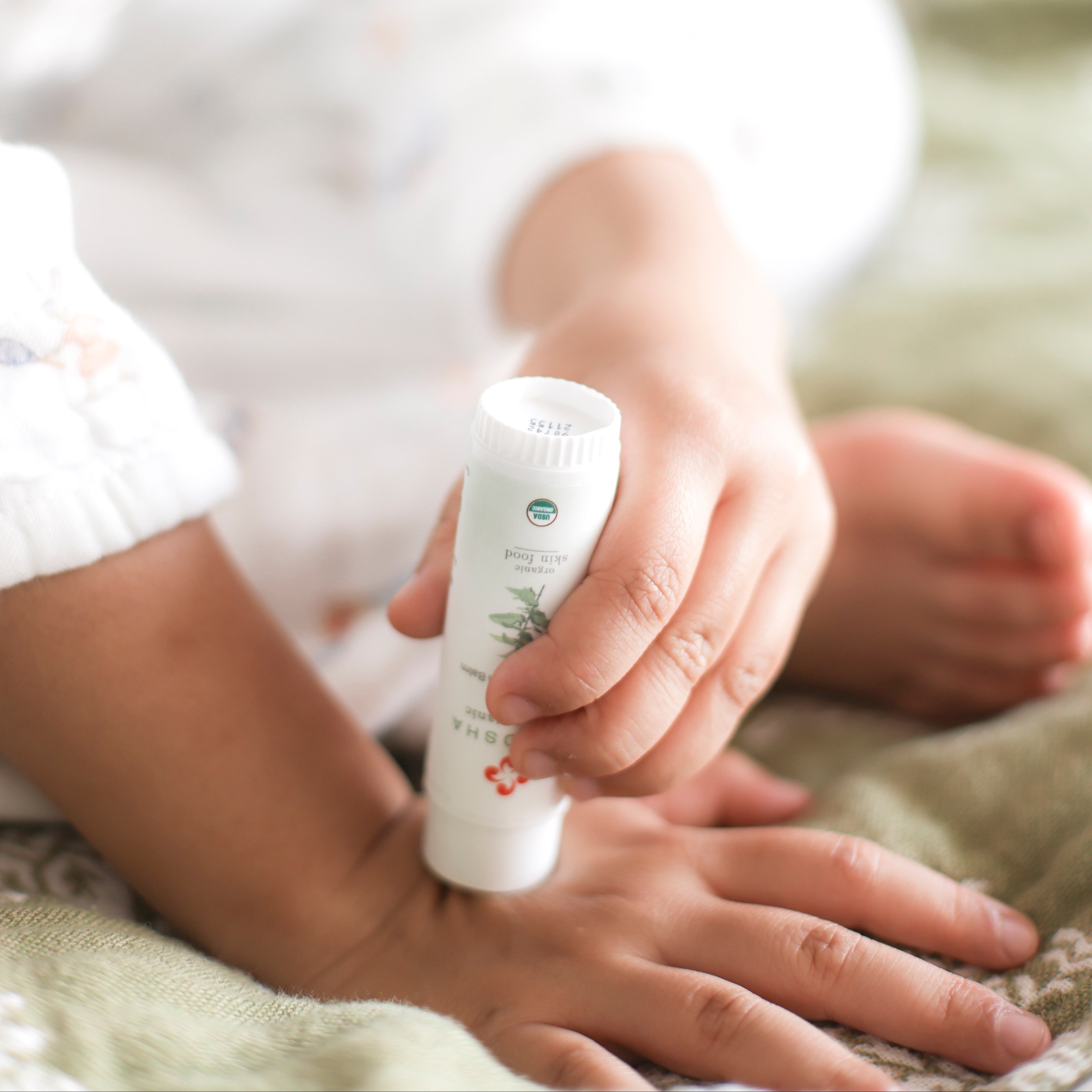 Child applying organic anti-itch cream to hand