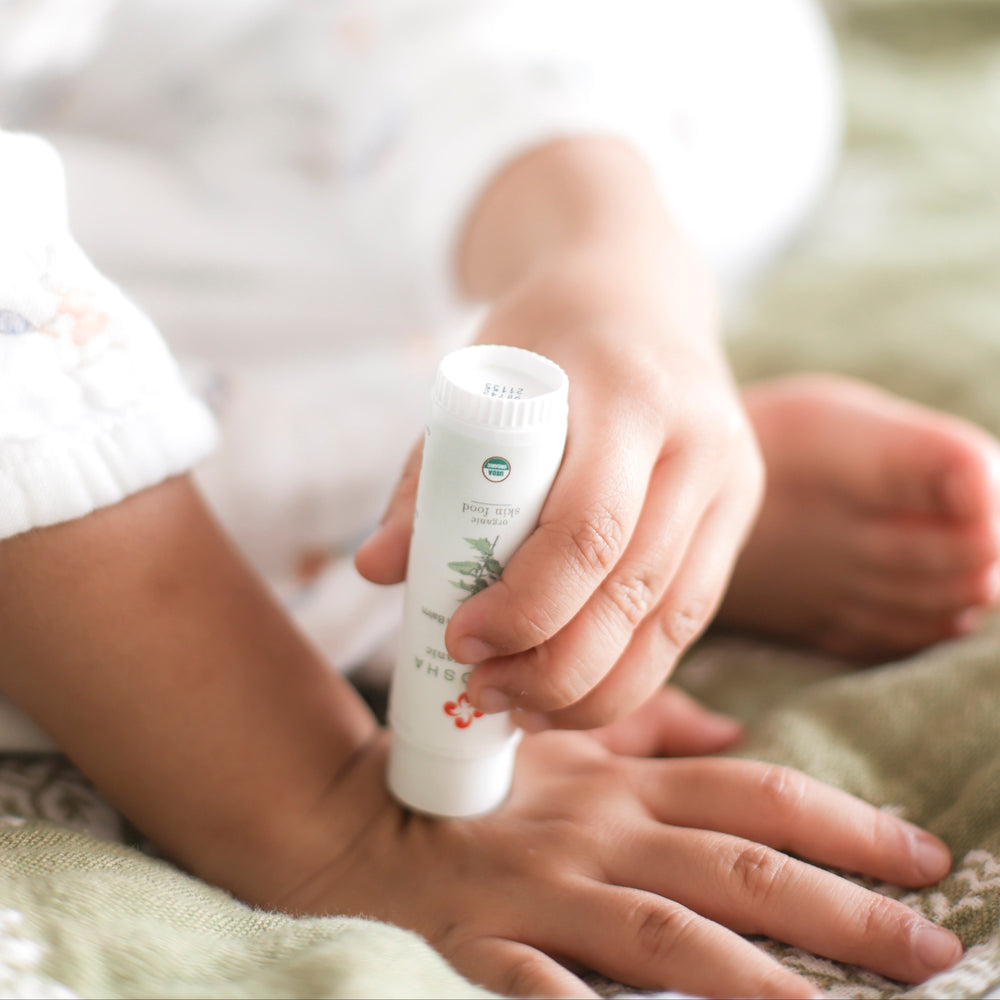Child applying organic anti-itch cream to hand